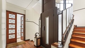 A wooden staircase with a dark wall and a door with a metal handle. - Feel Porto Downtown Heaven (Oporto)