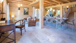 Ein geräumiges Holzhütten-Interieur mit Essbereich, einer Couch und einer Treppe.