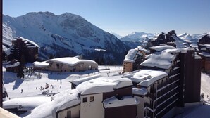 A snow-covered mountain town with buildings and a ski slope. - VERY NICE 2-ROOM APARTMENT FOR 4/5 PEOPLE, RECENTLY REFURBISHED (Morzine)