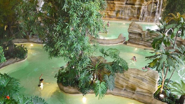 An indoor water park with multiple pools, lush greenery, and rock formations. - VERY NICE 2-ROOM APARTMENT FOR 4/5 PEOPLE, RECENTLY REFURBISHED (Morzine)