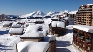 A snow-covered mountain resort with wooden buildings and a ski slope. - VERY NICE 2-ROOM APARTMENT FOR 4/5 PEOPLE, RECENTLY REFURBISHED (Morzine)