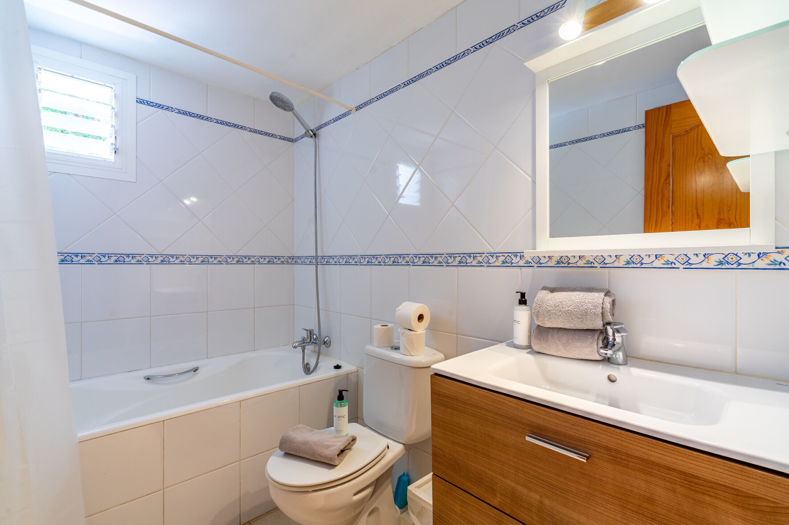Ein Badezimmer mit Badewanne, Toilette, Waschbecken und Spiegel.