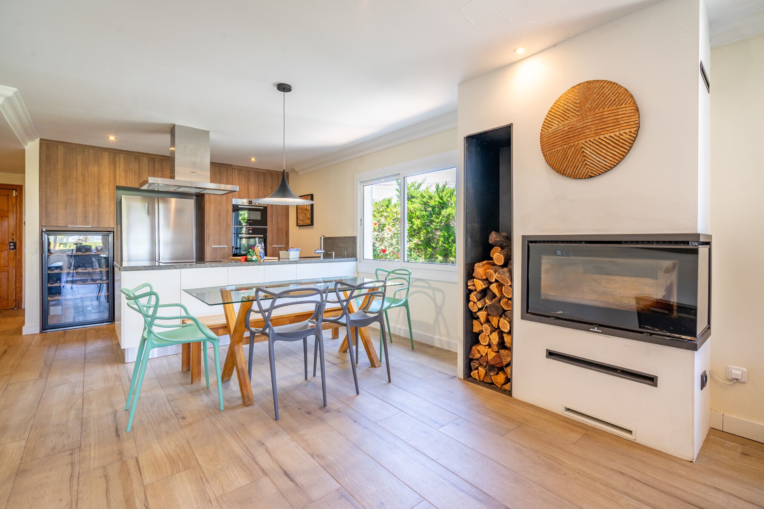 Una cocina moderna con comedor, horno empotrado y televisor.