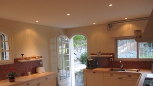 A kitchen with white cabinets, a sink, and a window.
