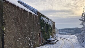 A snow-covered rural road with a stone building on the left. - HartHill Grange Bunkhouse - Unique 1850's Rural Country Accommodation (Lydney)