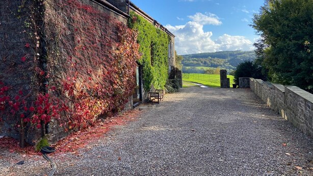 A gravel driveway leading to a stone wall and a building with ivy-covered walls. - HartHill Grange Bunkhouse - Unique 1850's Rural Country Accommodation (Lydney)