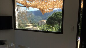 Un espace repas doté d’une grande fenêtre donnant sur un paysage montagneux.