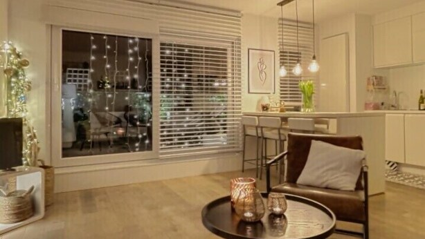 Ein modernes Wohnzimmer mit großem Fenster, einem runden Couchtisch und einer Couch.