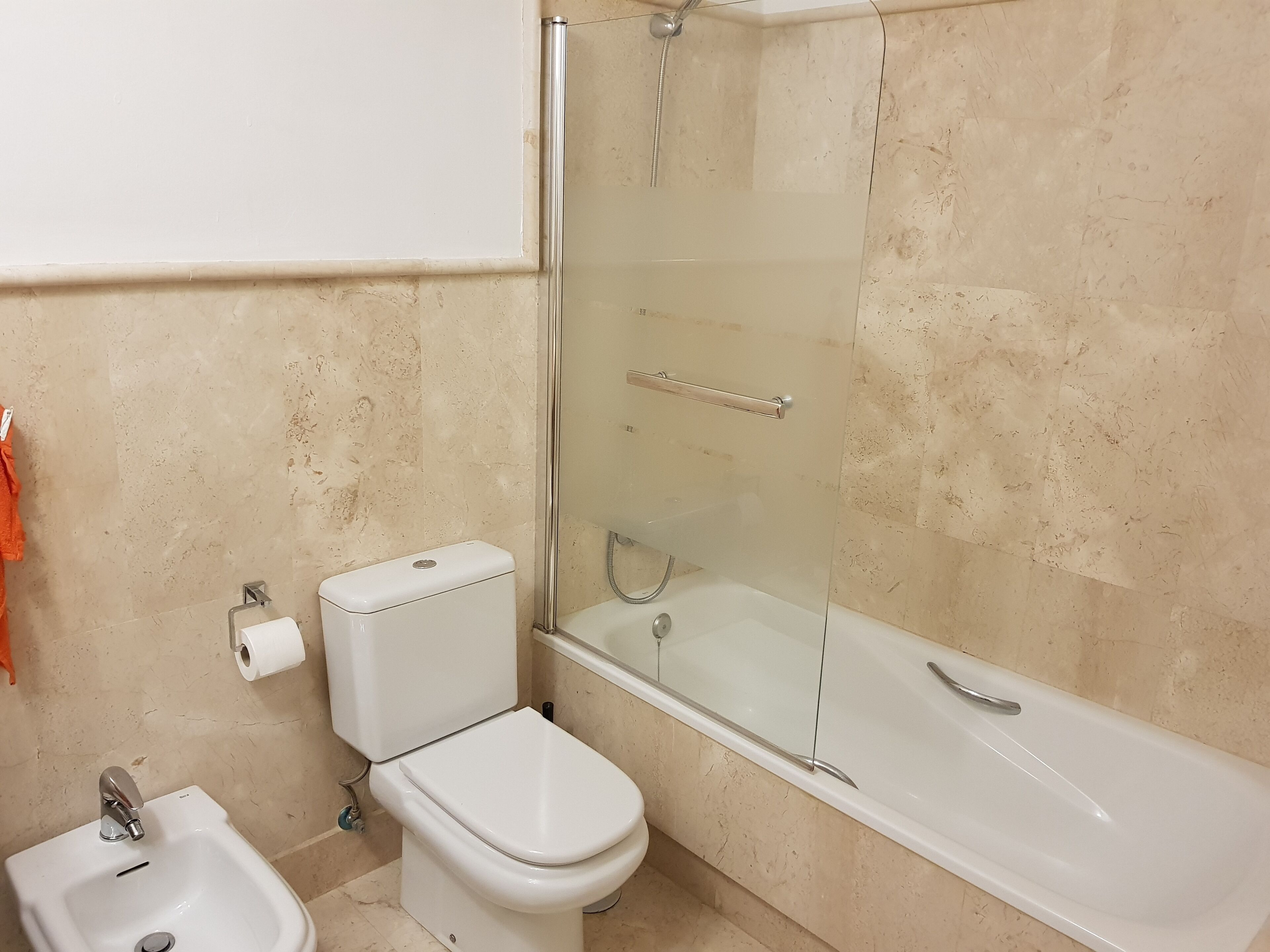 Ein Badezimmer mit Toilette, Bidet und einer Duschkabine.