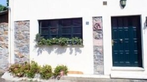 A two-story building with a white facade, stone accents, and a dark blue door. - Rural Accommodations Casa Fabián, La Quintana (Pet Friendly) (Castrillón)