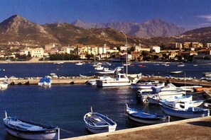 Boats are docked in the marina, offering scenic views of the surrounding mountains.