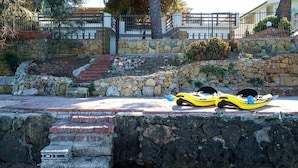 Un kayak amarillo sobre un saliente de piedra con una escalera de piedra y un muro de piedra al fondo.