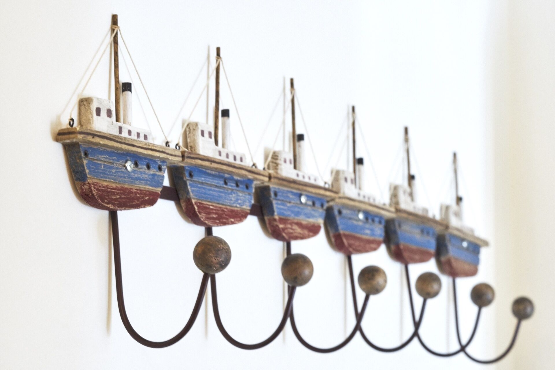 A series of model ships mounted on hooks.