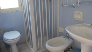 A bathroom with a toilet, bidet, and sink.