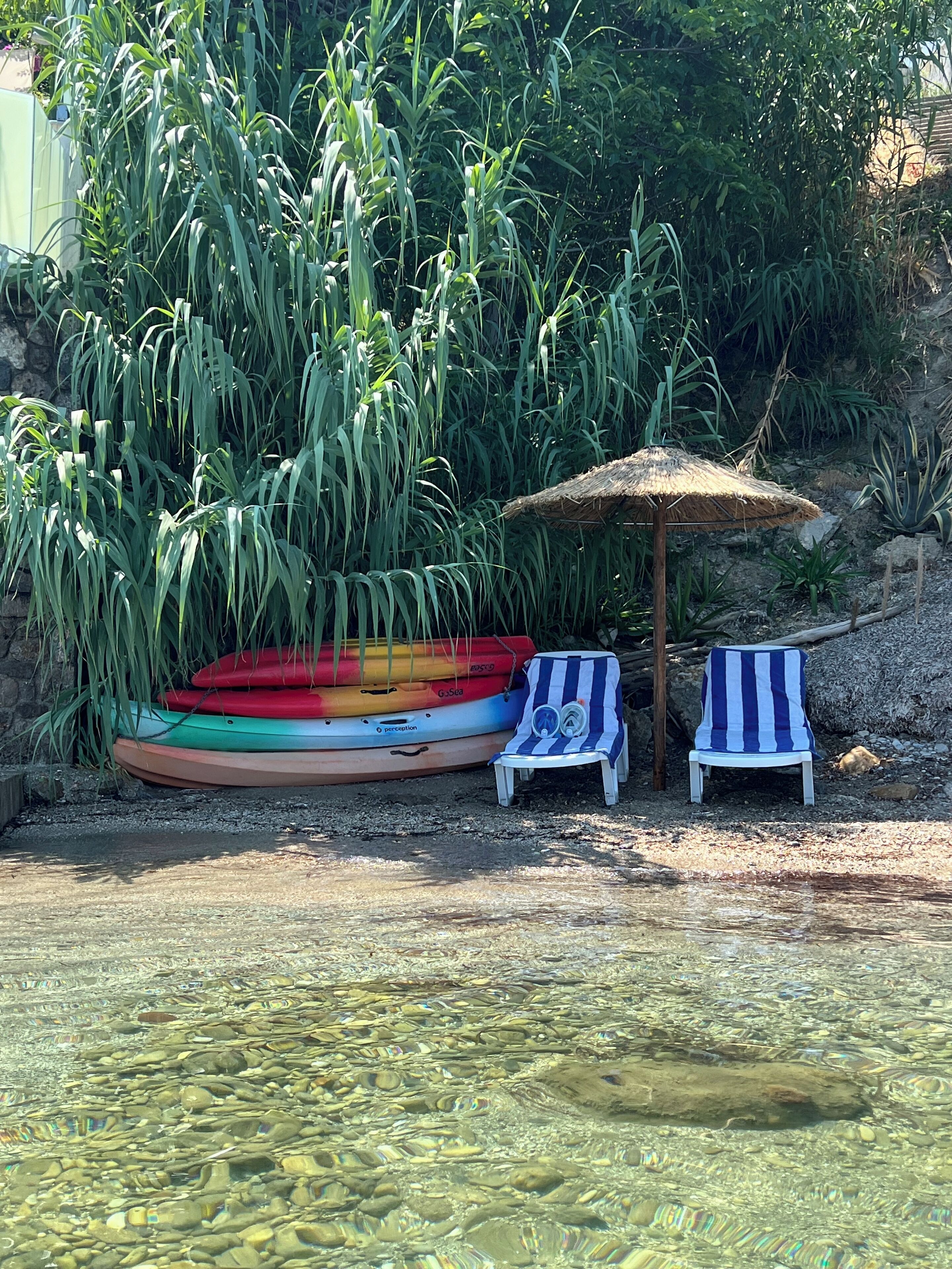 Beach with further sun lounges and coconut sun shade