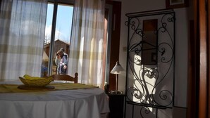 Une chambre à coucher avec un lit, une table de chevet, une lampe et une fenêtre avec des rideaux.