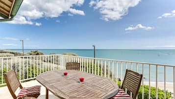 Enjoy a serene ocean view from this terrace with a table and chairs.