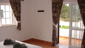 A hotel room with a bed, two towels, a window, and a view of the outdoors.