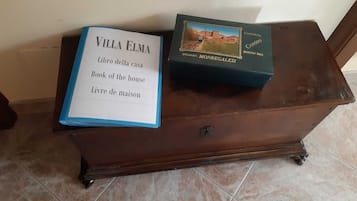 Two books on a wooden dresser with a tiled floor.
