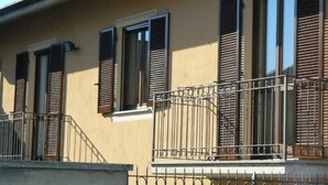 A building with multiple windows and balconies, featuring metal railings and shutters. - Villa Elma - Cozy Apartment In The Langhe (Cigliè)