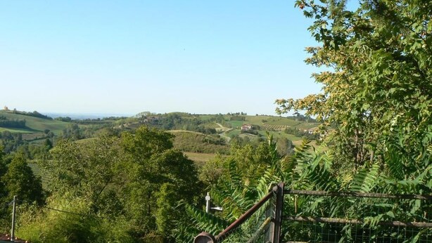 A rural landscape with a wooden fence and a metal gate, surrounded by lush greenery and rolling hills. - Villa Elma - Cozy Apartment In The Langhe (Cigliè)