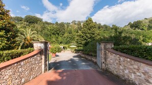 A stone pathway leading to a building surrounded by lush greenery. - Il Poggiolo, house between country and sea! (Montemagno)