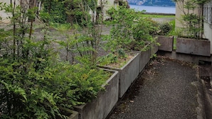 Un quartier résidentiel avec une maison dotée d’un balcon et offrant une vue sur un lac et des montagnes.