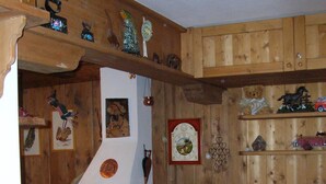 Un salon chaleureux avec des murs en bois, une cheminée, un téléviseur et un fauteuil à motifs.