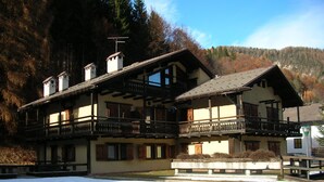Un bâtiment de style chalet traditionnel, doté de nombreux balcons, avec une piste de ski en premier plan.