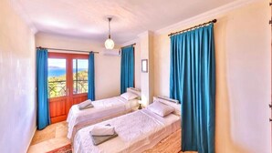 Una habitación con dos camas, vistas al exterior y una alfombra estampada.