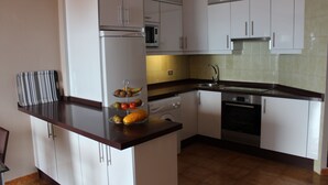 A kitchen with white cabinets, a microwave, an oven, and a sink. - Tenerife, La Arena Beach 300 m away, free Wi-Fi, community pool (Santiago del Teide)