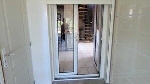 A sliding glass door leading to a tiled patio area with a staircase and outdoor seating. - 70m from the beach, pretty house 200m2, sea view, 6 bedrooms, 5 bathrooms, 7 wc, enclosed garden, 15 people (Poggio-Mezzana)