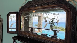 Un espejo con marco rústico, una toalla y vistas a una piscina exterior y al paisaje.