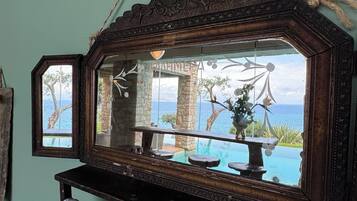A mirror with a rustic frame, a towel, and a view of an outdoor pool and landscape.