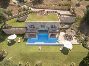 A stone building with a flat roof, a swimming pool, and outdoor seating. - Villa Seashore: Dreamy villa by the sea side with heated pool (Corfu)
