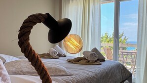 Un dormitorio con cama, lámpara de noche y vistas al exterior.