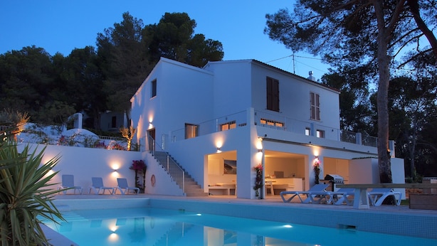 Une maison moderne à deux étages, dotée d’une piscine, d’un espace extérieur aménagé et d’un escalier menant à l’étage supérieur.