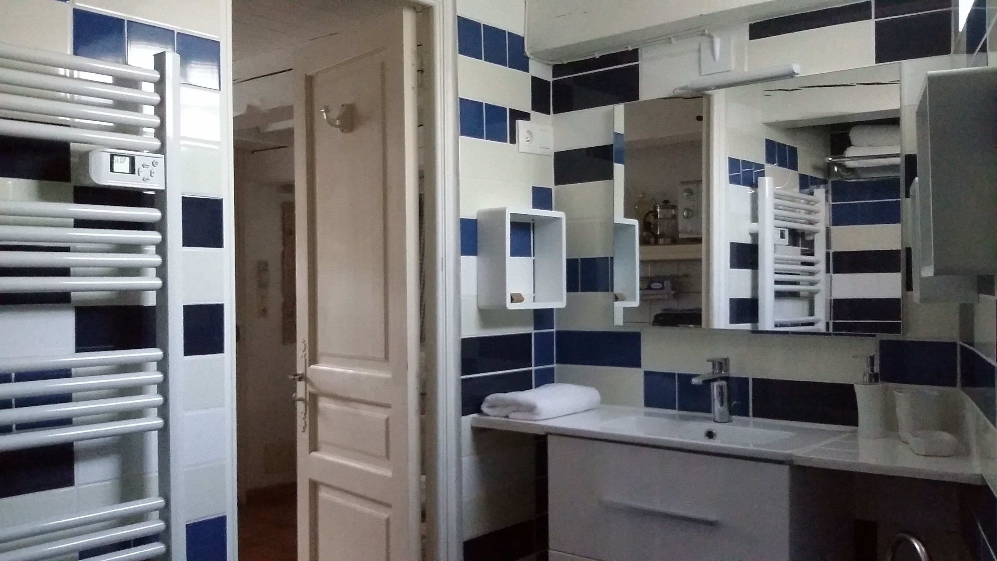 A bathroom with a white sink, a mirror, and a towel rack.