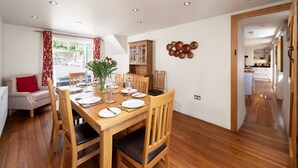 Een eetgedeelte met een houten tafel voor vier personen, omringd door houten stoelen.