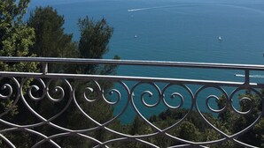 A balcony with a view of the sea, a clear sky, and distant land. - confortable cottage with stunning seaview and total privacy in the nature (Montemarcello-Ameglia (SP))