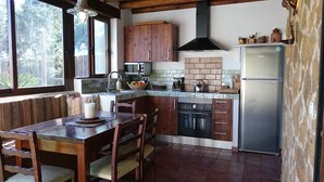 A compact kitchen with wooden cabinets, a built-in oven, and a stainless steel refrigerator.