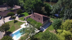 A residential area with a swimming pool, two houses, and a river. - CHARMING PERIGOURDINE ALONG THE DORDOGNE (Cours-De-Pile)