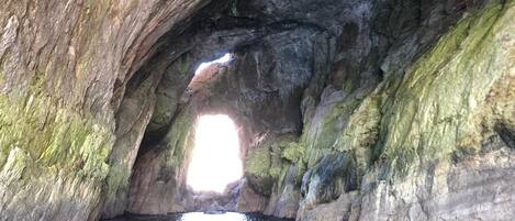 A natural rock formation with a water body at its base.