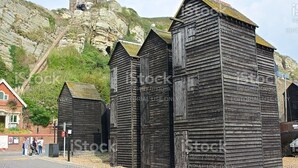 A row of wooden buildings with a stone bridge in the background. - Beautiful Seaside Cottage 1 minute from the beach - The Tides (Camber)