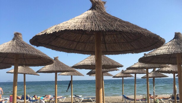 A beach with multiple thatched umbrellas and sun loungers. - Puerto Marina 2 bedroom 2 bath apartment in Los Alcazares (Murcia)
