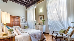 Un dormitorio con cama, cómoda, silla y espejo.