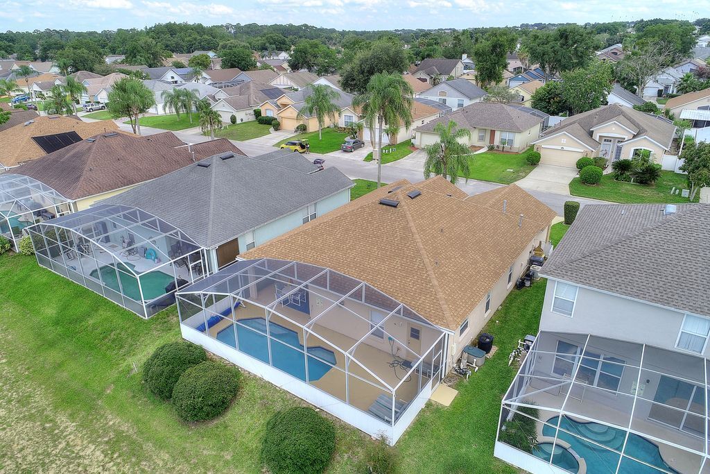 A residential area with houses featuring large glass-enclosed swimming pools.