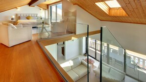 Ein modernes Schlafzimmer im Loft-Stil mit Glasdecke, einem großen Bett und einem Balkon mit Sitzgelegenheit.