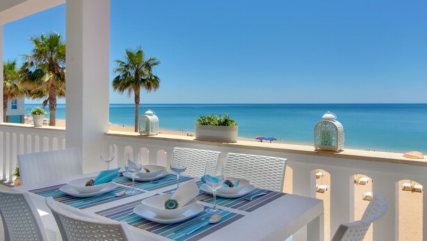 Ein Tisch für zwei Personen mit Blick auf Strand und Meer.