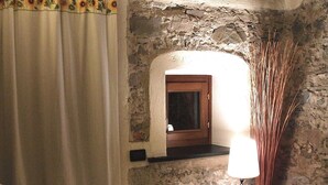 A cozy living room with a stone wall, a wooden ceiling, a sofa, a lamp, and a curtain. - Elegant escape sea view private pool & gardens perfect starting point MTB&hiking (Alassio)